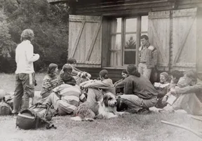 Foto antigua de profesores y estudiantes sentados en el césped